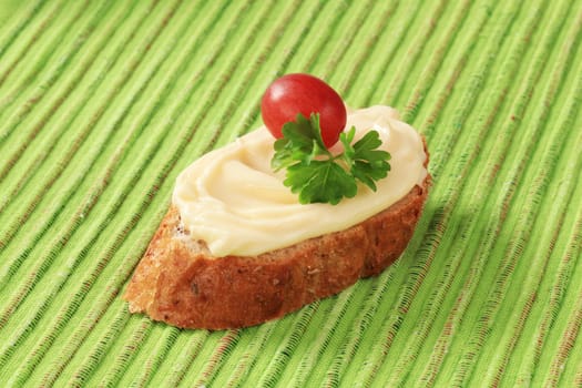 Slice of bread roll and creamy cheese spread