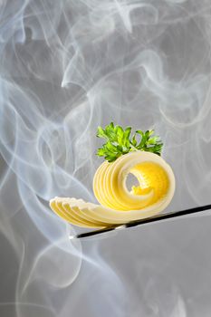 Butter curl on a knife in steam