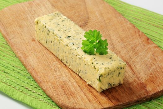 Stick of fresh herb butter on a cutting board