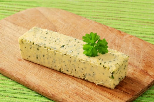 Stick of fresh herb butter on a cutting board