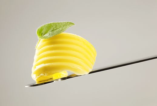 Curl of fresh butter on a knife 