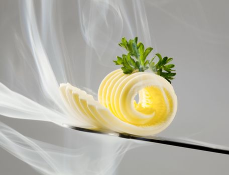 Butter curl on a knife in steam
