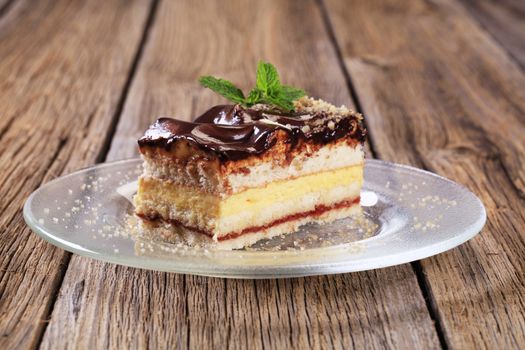 Slice of vanilla cream cake with chocolate icing