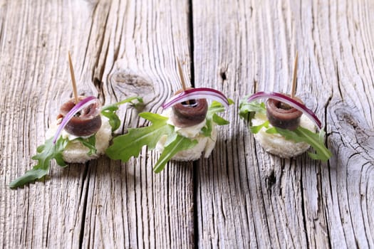 Anchovy canapes garnished with greens and onion