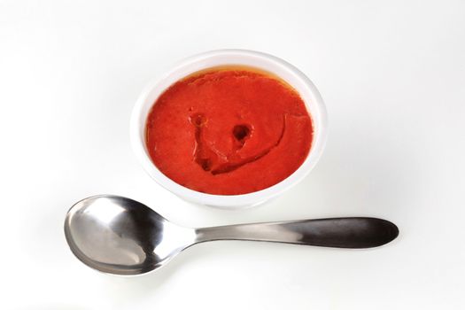 Bowl of tomato paste and spoon 