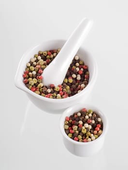 Mix of peppercorns in a porcelain mortar
