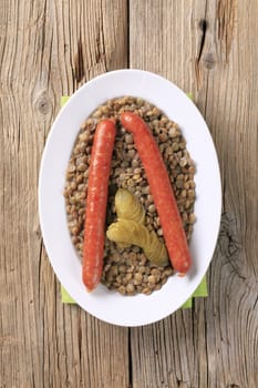 Cooked lentils with spicy sausages and pickles 