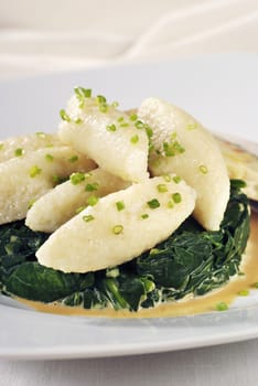 Potato dumplings on a nest of spinach leaves
