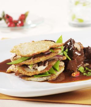 Venison goulash served with potato pancakes and vegetable