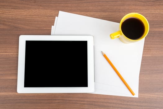 Tablet with blank paper and coffee on wooden table