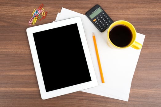 Tablet with blank paper and coffee on wooden table