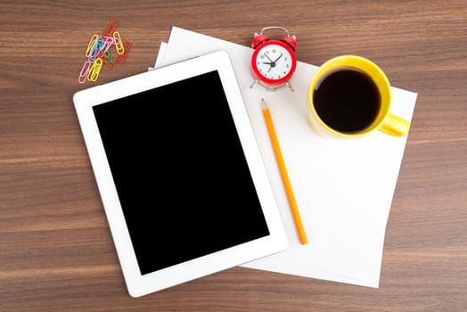 Tablet with blank paper and coffee on wooden table