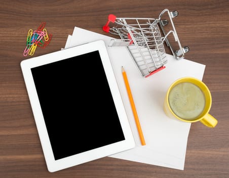 Tablet with blank paper and coffee on wooden table