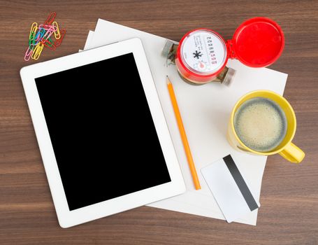 Tablet with blank paper and coffee on wooden table