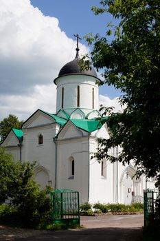 Small white orthodox church in a garden
