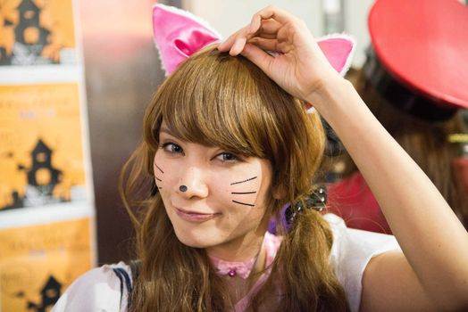 JAPAN, Tokyo : A woman wearing a cat costume as she poses for pictures while taking part in a Halloween parade in Tokyo on October 31, 2015. Tens of thousands of people gathered at Tokyo's Shibuya fashion district to celebrate Halloween.