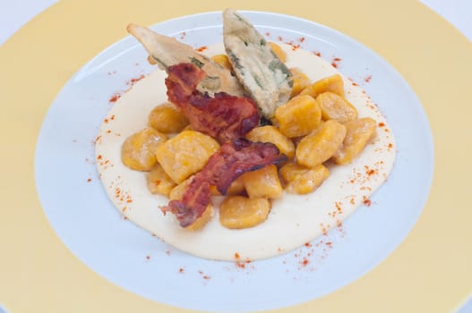 Gnocchi with pumpkin and peanut butter and crispy bacon,italy