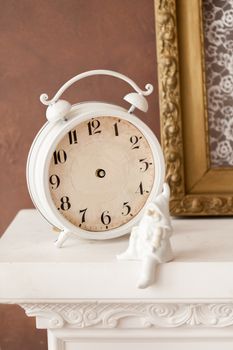 old watch and gnome figurine on the mantel