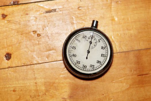 old and vintage stopwatch over a wooden surface