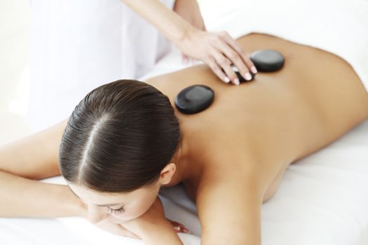 Girl on a stone therapy, hot stone massage