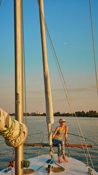 Woman traveling by boat at sunset among the river