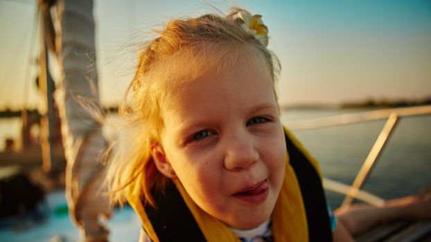 Little girl enjoying ride on yacht at sunset