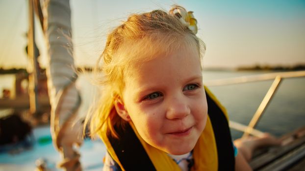 Little girl enjoying ride on yacht at sunset