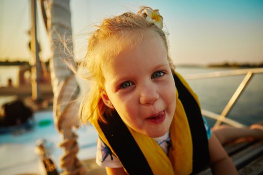 Little girl enjoying ride on yacht at sunset