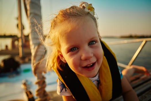 Little girl enjoying ride on yacht at sunset