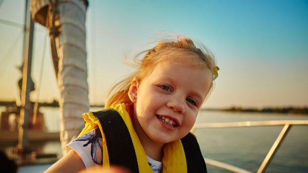 Little girl enjoying ride on yacht at sunset