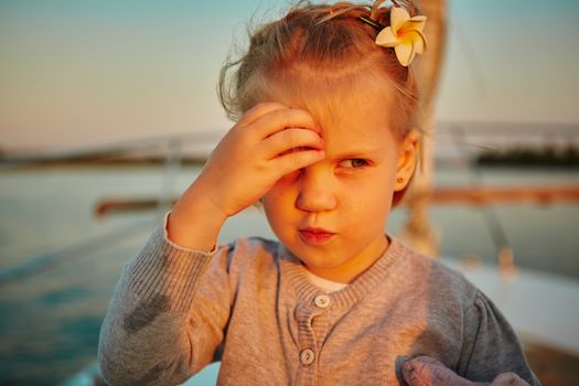 Little girl enjoying ride on yacht at sunset