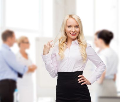 business, team work and people concept - smiling businesswoman, student or secretary over group of colleagues in office background