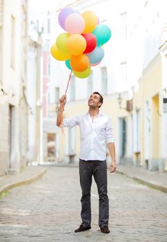 summer holidays, celebration and lifestyle concept - man with colorful balloons in the city