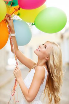 summer holidays, celebration and lifestyle concept - beautiful woman with colorful balloons in the city