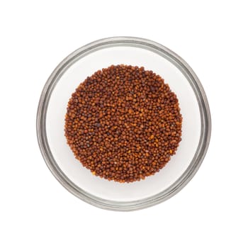 Top view of Organic Small Brown Mustard Seeds (Brassica juncea) half filled in glass bowl isolated on white background.