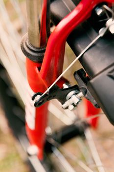 Close up of front brake of red and black mountain bicycle.