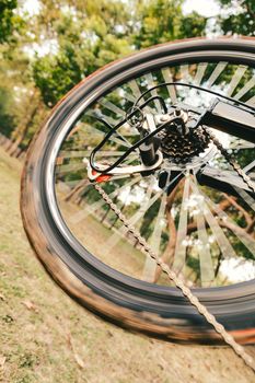 Close up of a running bicycle rear wheel with details, chain and gearshift mechanism.