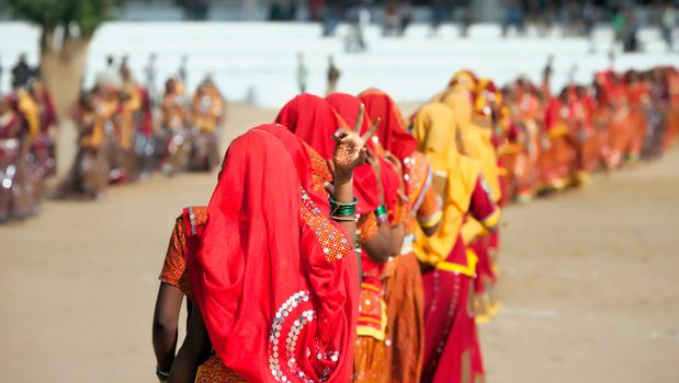 Indian girls in colorful ethnic attire dancing at Pushkar fair, Pushkar, Rajasthan, India, Asia
