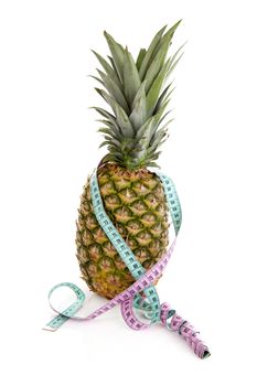 Fresh pineapple with measure tape over white background