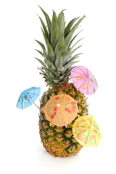 Tropical pineapple with cororful umbrellas over white background