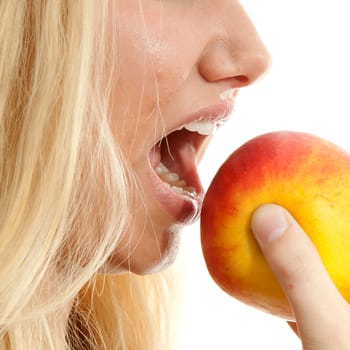 healthy lifestyle: portrait of young blonde woman eating delicious apple in closeup over white background