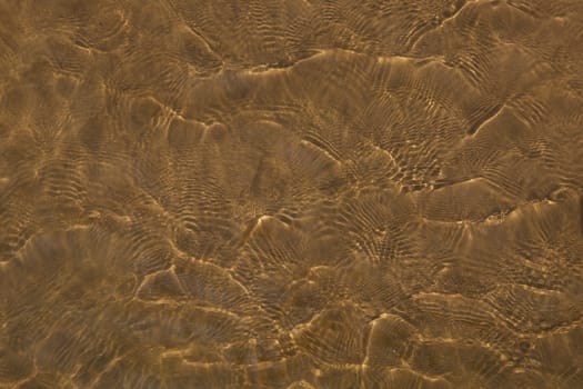 Reflections of water on the river Oka, on the sandy beach.
