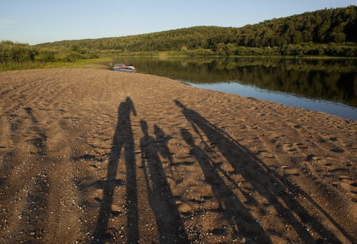 Silhouettes on the sandy beach near the Oka River in the summer.