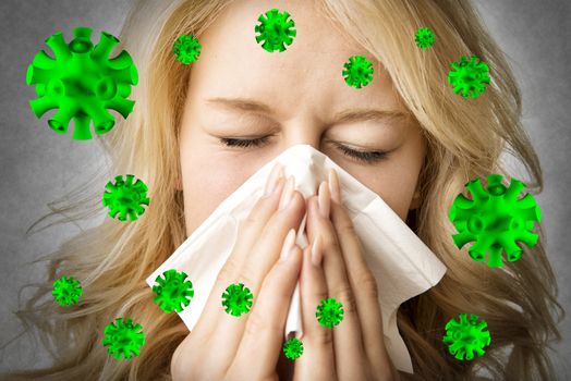 Portrait of a ill blond woman who is sneezing virus  in a tissue