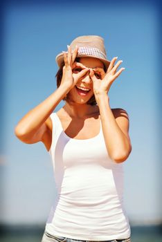 summer holidays and vacation - girl making funny faces on the beach