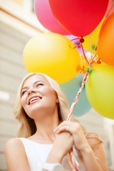 summer holidays, celebration and lifestyle concept - beautiful woman with colorful balloons in the city