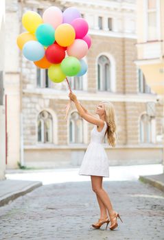 summer holidays, celebration and lifestyle concept - beautiful woman with colorful balloons in the city