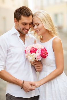 summer holidays and dating concept - couple with bouquet of flowers in the city