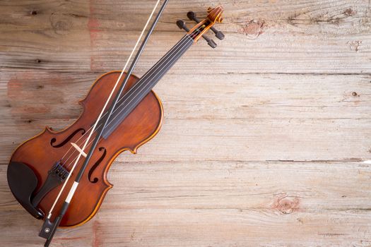 High Angle View of a Violin Musical Instrument Lying on a Wooden Floor with Copy Space on the Right Side.