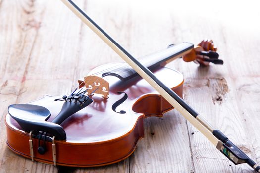 Close up Small Violin Musical Instrument for Kids Resting on a Wooden Floor.